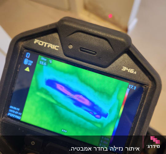 מצלמה תרמית מציגה תמונה עם אזור חם על קיר